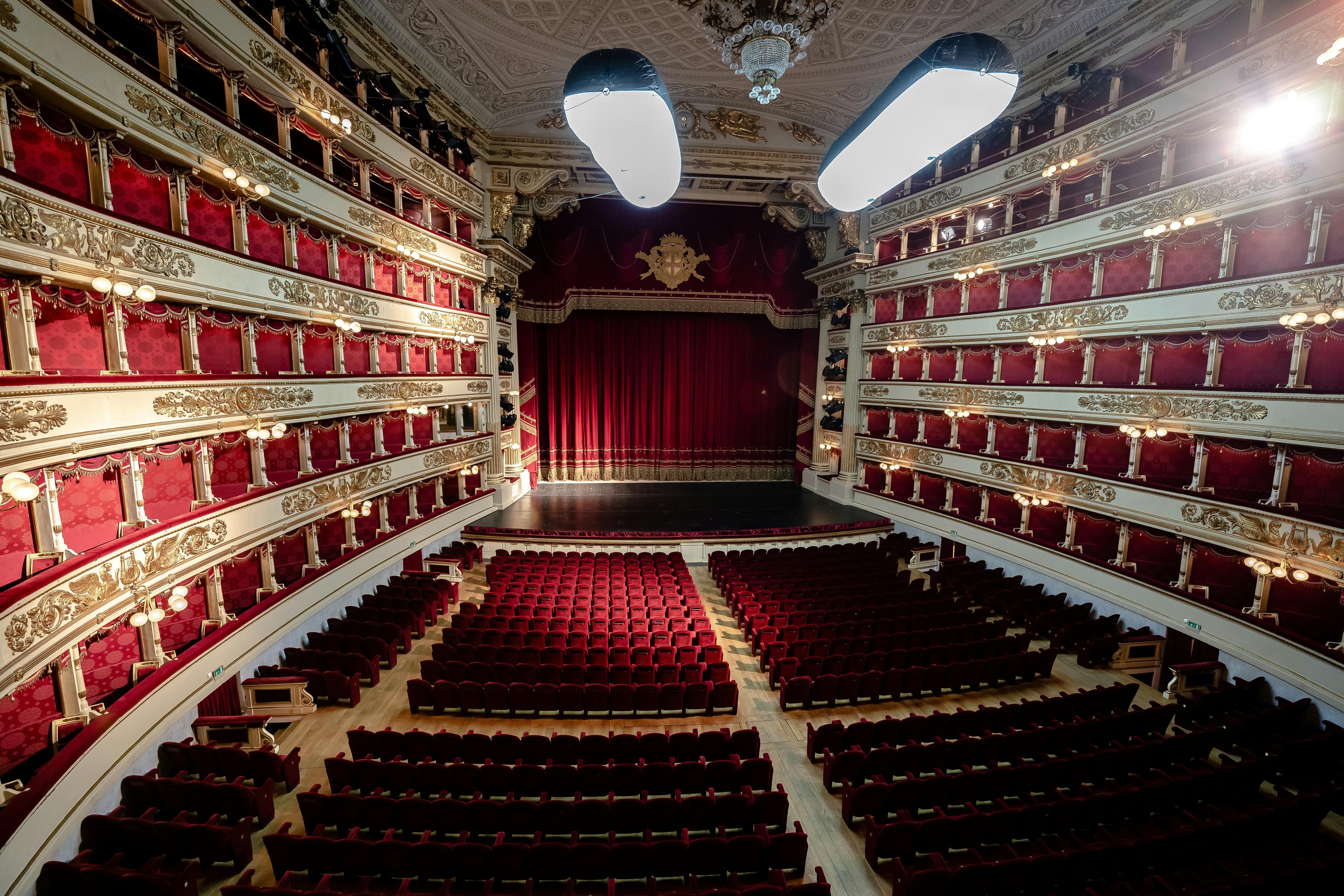 Empty opera house auditorium with ornate balconies.